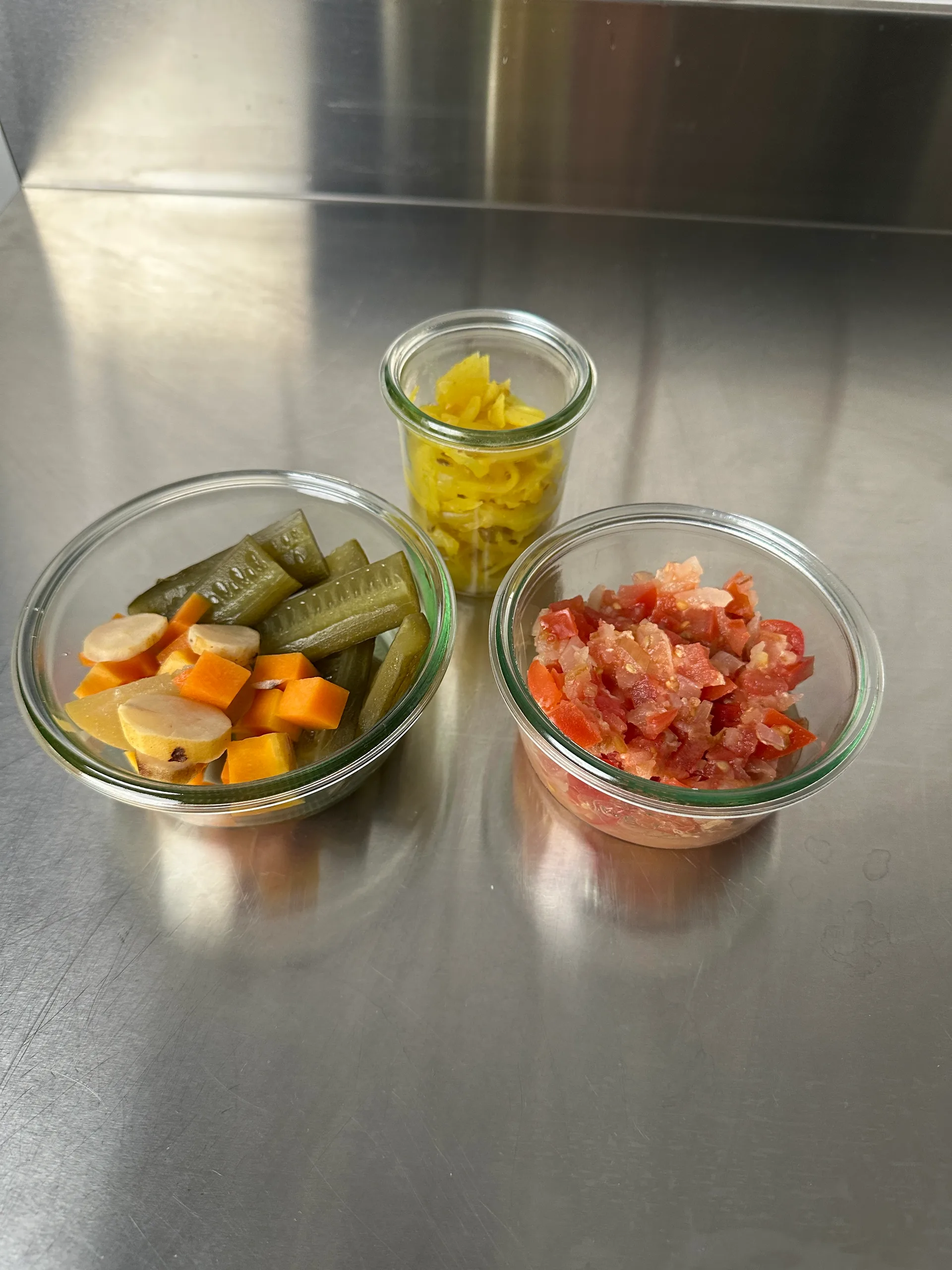 Fermentiertes Gemüse wie Salzgurken, Kürbis-Pickels, Tomatensalsa und Curryzwiebel.